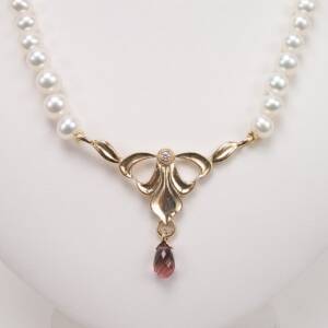 14k yellow gold necklace with 2.89cts pink tourmaline and .06cts of diamonds in the center of AAA Pearls