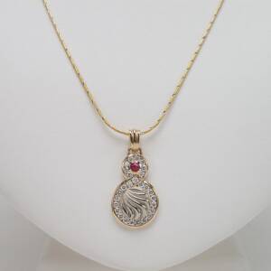 Pendant  in 14K two tone with .25ct  Ruby Cabochon and .75cts of diamonds